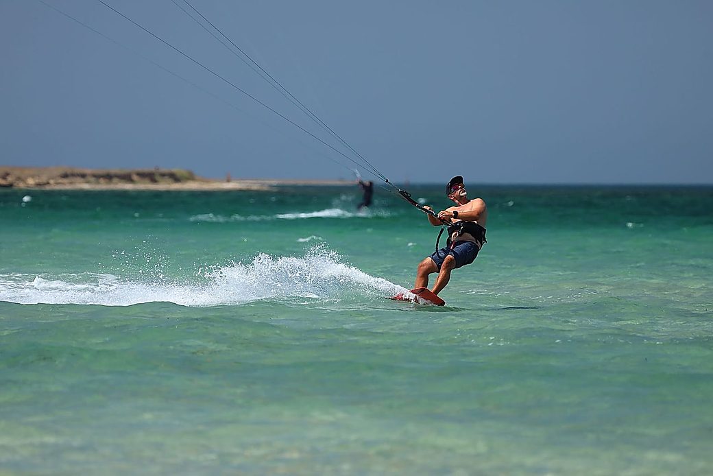 Kitesurf riders on the turquoise lagoon at sunset